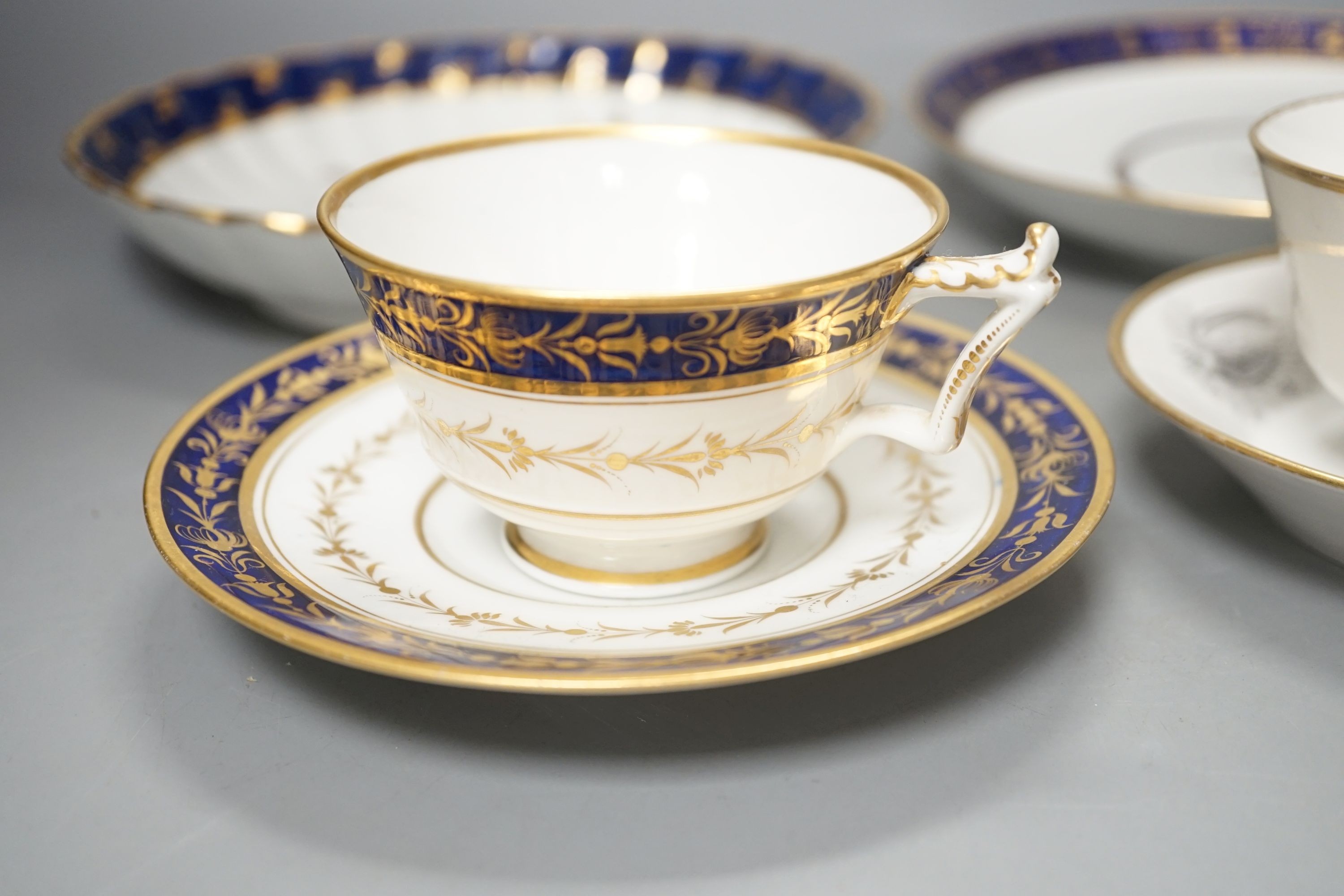 A Flight Barr and Barr teacup and saucer printed with shells, similar teacup and saucer with blue and gold decoration, and two Flight Barr and Barr gold and blue saucers dishes c. 1820, dish 20 cms diameter.